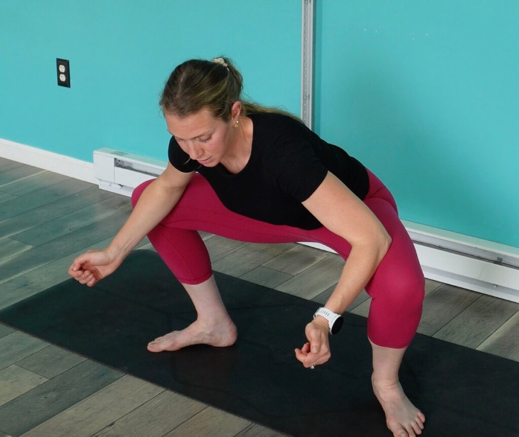 Dr. Chloe with her toes facing outward, hinged at the hips, and squatting down to stretch her adductors for her running form